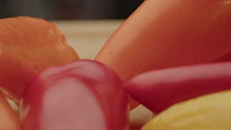 macro of several paprika's on a wooden cutting board