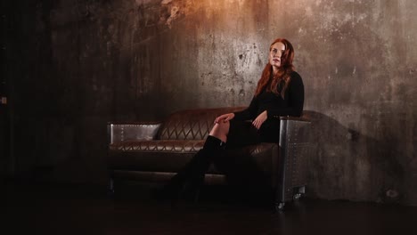 woman sitting on a leather couch in an industrial interior