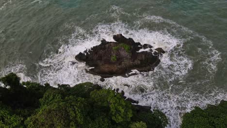 ocean white foam coast tide breaking against rocky shore formations aerial dolly left