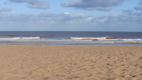 Wellen-Am-Strand-Im-Vereinigten-Königreich-Mit-Wolken-Und-Blauem-Himmel