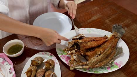 two people serving and sharing fish and soup