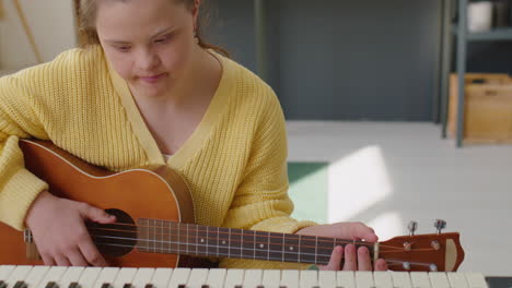 girl with down syndrome singing and playing guitar