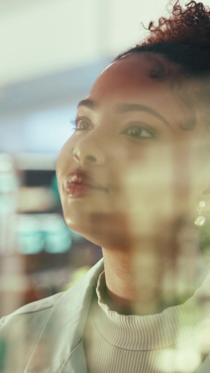 Thoughtful Young Woman Looking Through Window in Modern Office