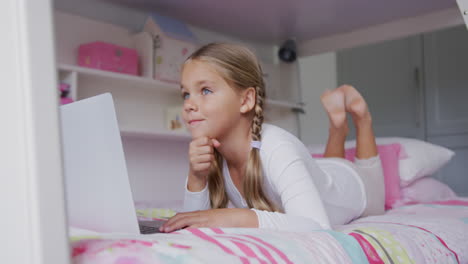 Girl-using-laptop-in-bedroom-at-comfortable-home-4k