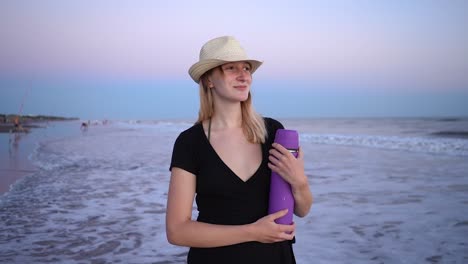 Bella-Dama-Con-Sombrero-De-Verano-Sosteniendo-Un-Termo-Morado-En-La-Playa-De-Monte-Hermoso,-Buenos-Aires,-Argentina