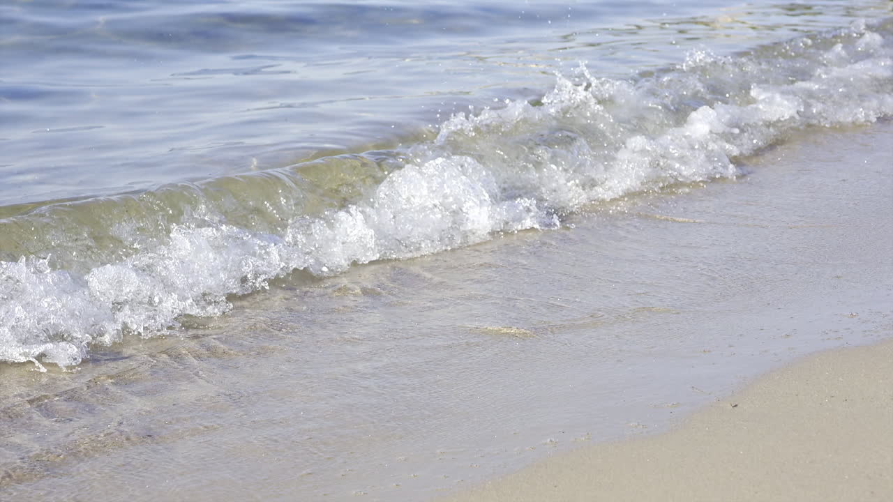 Close up of waves crashing on the beach in daylight