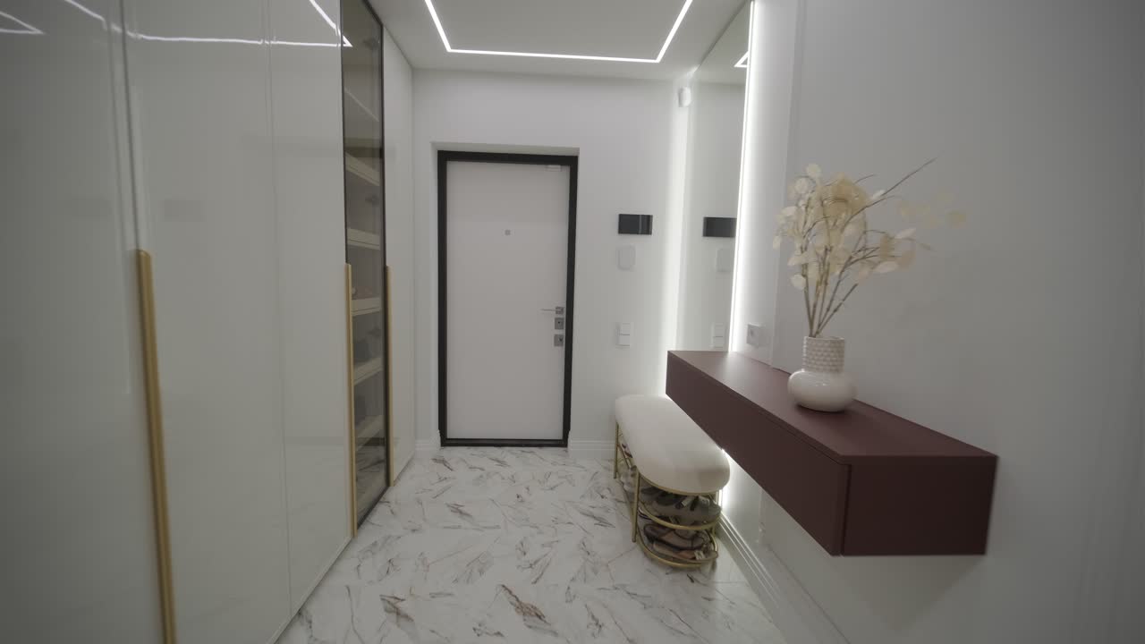 Sleek and modern hallway with geometric LED ceiling lights, marble floors, and a minimalist aesthetic