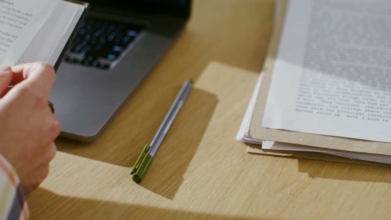 책을 읽고 노트북에서 일하는 사람