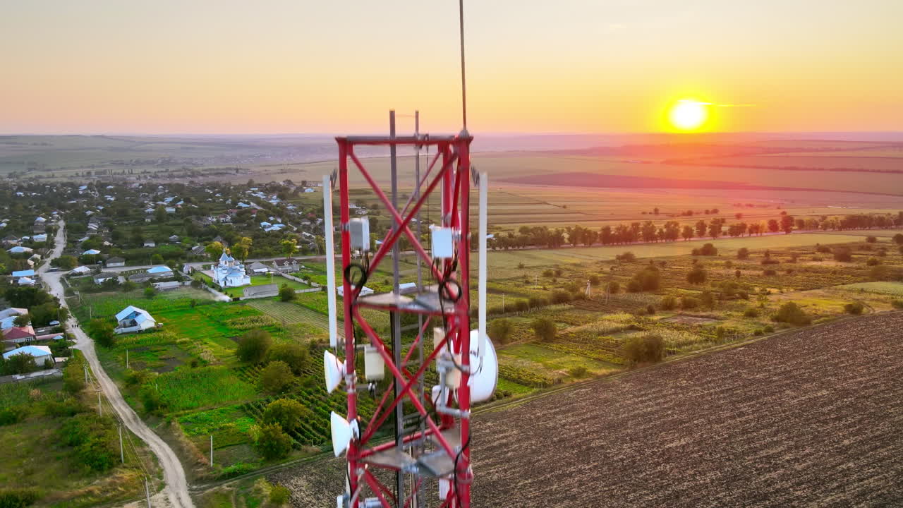 Aerial drone view of a communication tower, located near a village in Moldova. Sunset