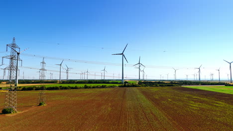 power lines and wind turbines in the fields. sustainable energy production in the countryside. aerial view