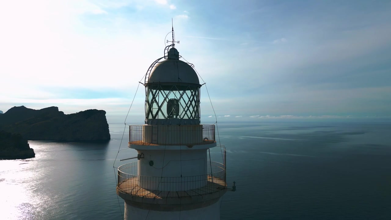 Faro iconico a Cap de Formentor con scogliere drammatiche, montagne e formazioni rocciose al tramonto. La bellezza naturale del mare blu profondo sull'isola balearica di Palma di Maiorca. Drone aereo cinematografico 4K UHD.