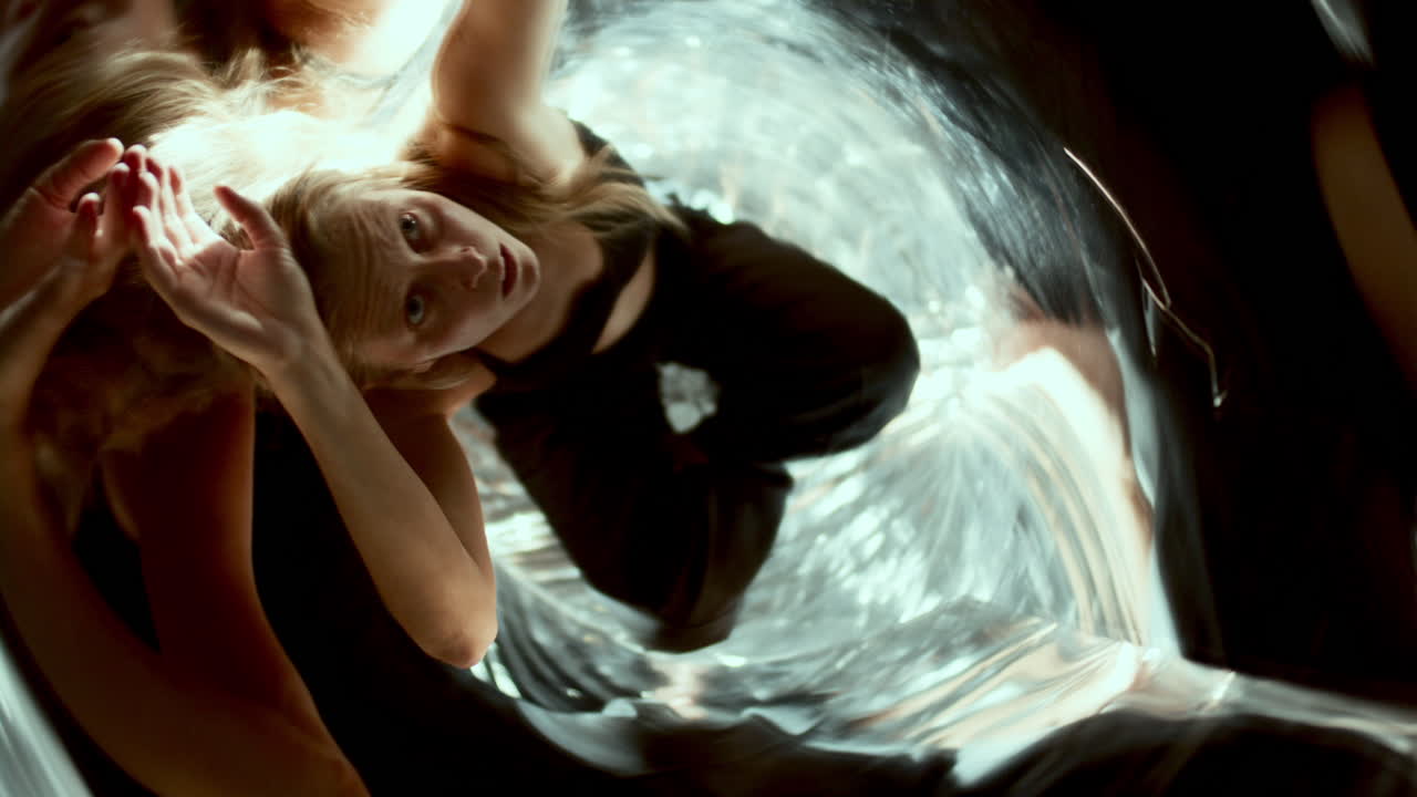 Expressive Woman Moving Gracefully in Distorted Mirror Reflections