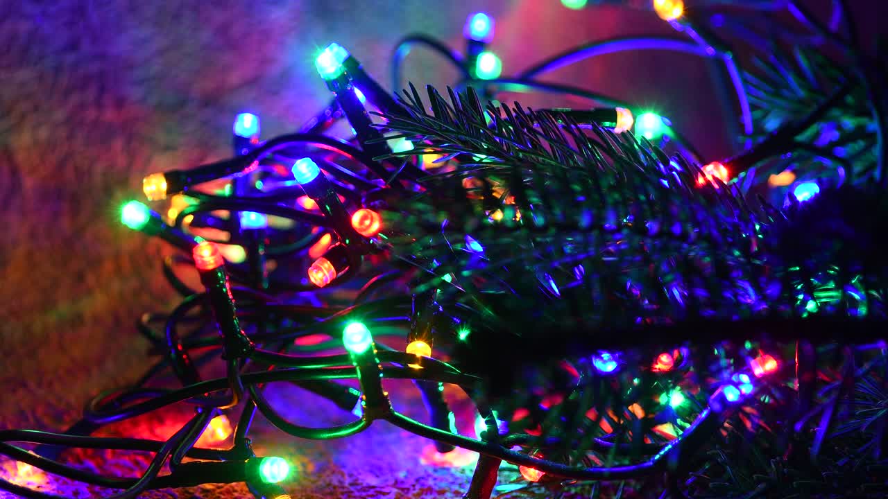 las luces de navidad de colores parpadeantes con la rama de abeto verde.