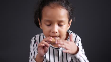 young girl eating a cookie