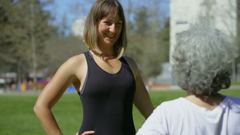 Lächelnde-Junge-Frau-Trainiert-Mit-älterer-Dame-Im-Park.