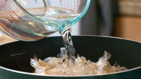 pouring water over shrimp shells to render seafood stock for gumbo - isolated