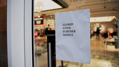 coronavirus covid-19 sign in clothing shop window during lockdown saying closed until further notice, showing clothes shops shut in london on a shopping high street in the pandemic in england, europe