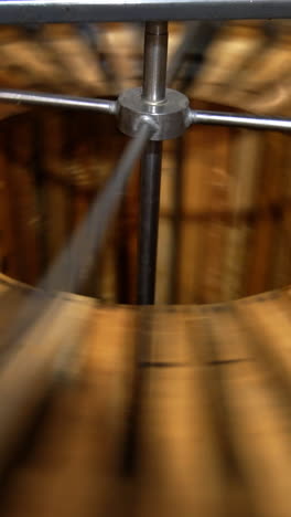 process of honey extraction in the electric centrifuge device. many wooden frames are rotated for taking honey out of cells. vertical video