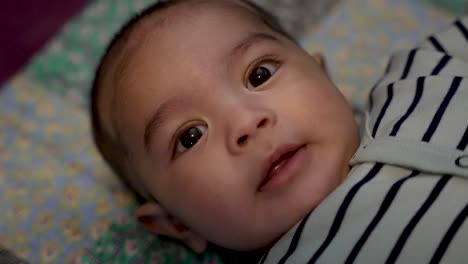 Vista-De-Cerca-Del-Adorable-Bebé-Indio-De-4-Meses-Sonriendo-Y-Siendo-Expresivo-Mirando-A-La-Cámara-Acostado-En-La-Alfombra-De-Juego