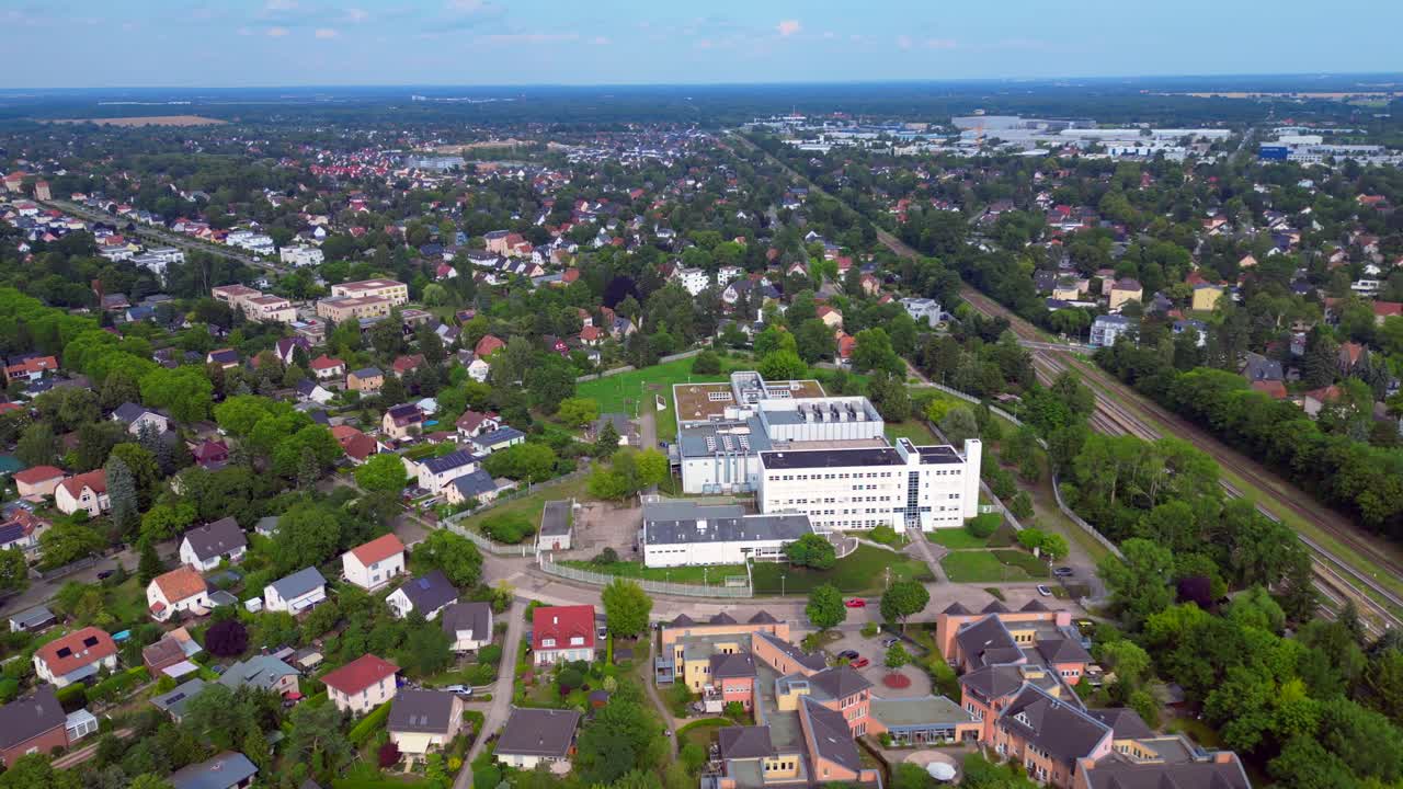 datacenter building with cooling system on the roof, surrounded by residential houses, showcasing urban and industrial integration. panorama orbit drone
