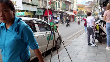 vendor carrying goods on busy street