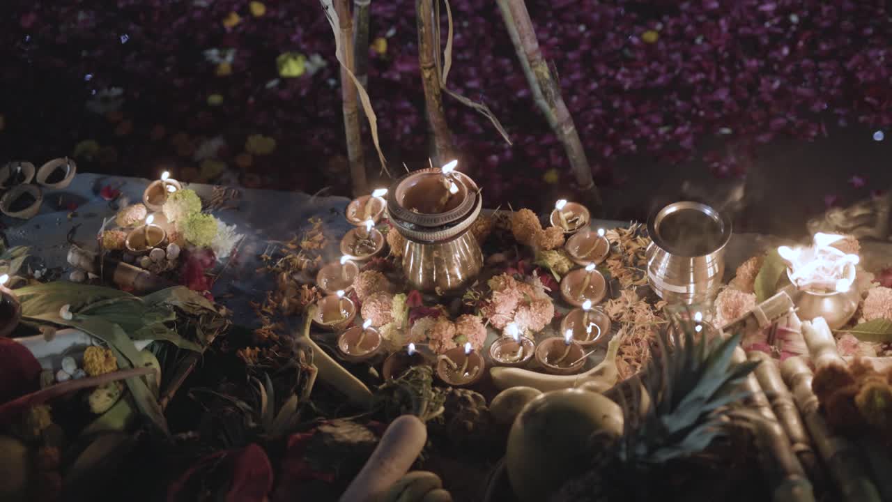 ofrendas sagradas tradicionales de lámparas de aceite ardientes a la orilla del río en el festival de chhath por un devoto