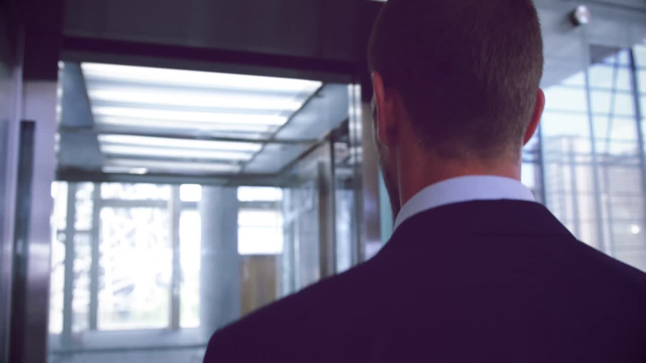 Uomo d'affari che sale sull'ascensore in un ufficio moderno 4k