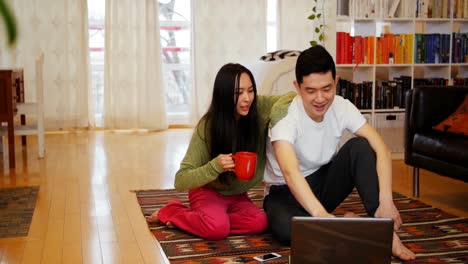 couple using laptop in living room