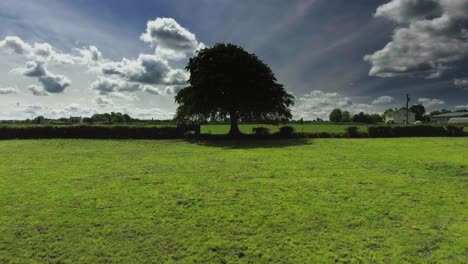 aerial drone shot of farmer driving a tractor in ireland