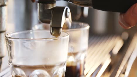 primer plano de un espresso que se vierte de la máquina de café