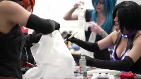 passionate creators in action: cosplayers collaborate on costume design and painting techniques in a colorful workshop environment