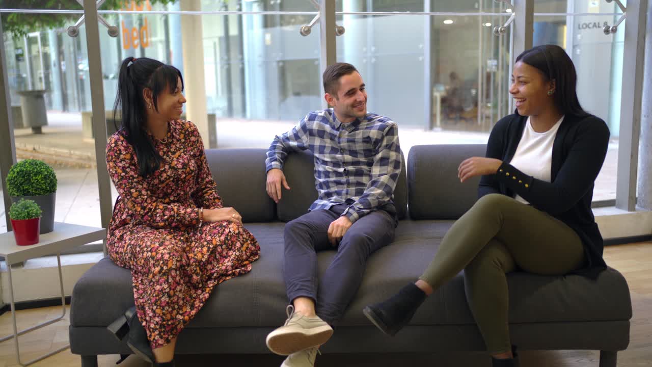 사무실에서 소파에 앉아 있는 다민족 동료들