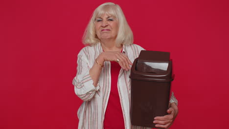 Smiling-senior-woman-taking-off,-throwing-out-glasses-into-bin-after-vision-laser-treatment-therapy