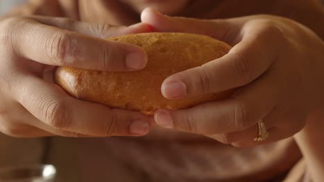 hands breaking a freshly baked bread loaf