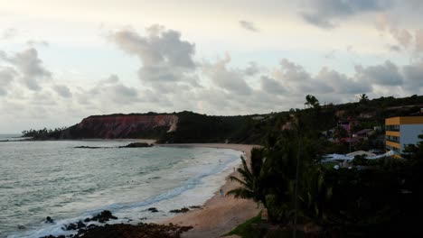 Aerial-drone-shot-flying-past-palm-trees-to-reveal-large-tropical-colorful-cliffs-on-the-exotic-beach-of-Tabatinga-in-Northern-Brazil-near-Joao-Pessoa-on-a-warm-summer-morning