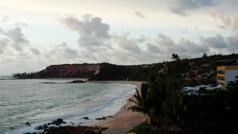 un dron aéreo disparó sobre las palmeras para revelar grandes acantilados tropicales coloridos en la exótica playa de tabatinga en el norte de brasil cerca de joao pessoa en una cálida mañana de verano