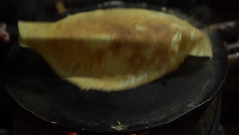 hombre vendedor sacando un crepe cocido de la plancha de metal en un mercado callejero mexicano