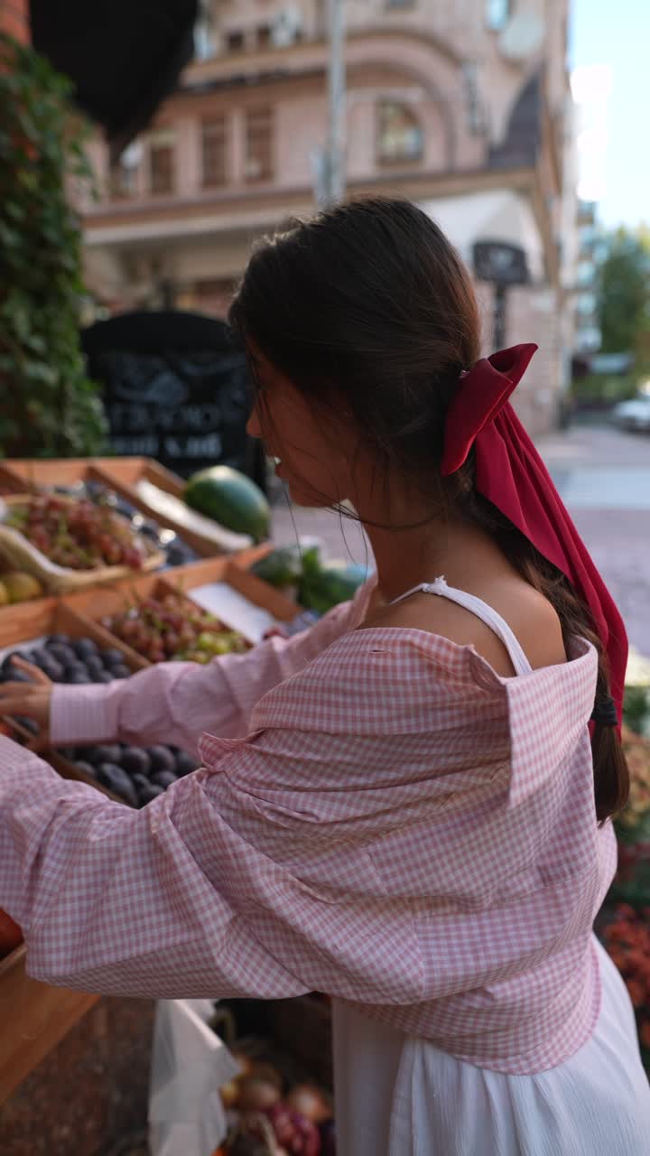 mujer comprando frutas en un mercado callejero
