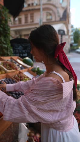 woman shopping for fruit at a street market