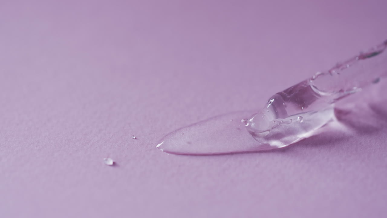 vídeo de la pipeta de maquillaje y las gotas de suero con espacio de copia en fondo rosa