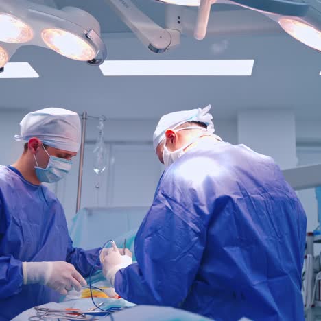 surgical process in the operating room. two surgeons in medical uniform performing a surgery to a patient in the modern hospital.