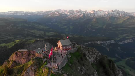 Vista-De-Drone-Temprano-En-La-Mañana-A-La-Cima-De-La-Montaña-Suiza-Con-Restaurante-De-Montaña-Y-Primeros-Invitados