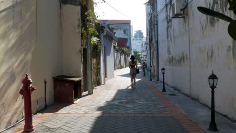 young female walking through a deserted street in penang, malaysia