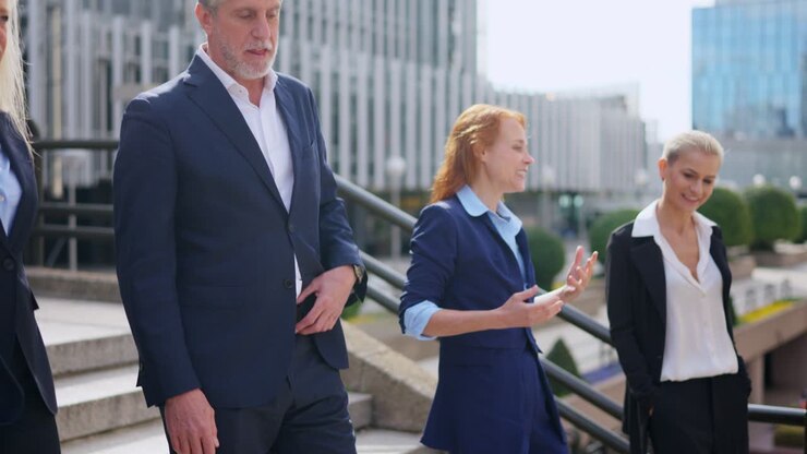 Business professionals walking and talking outdoors in an urban setting