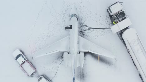 refueling of private business jet airplane with snow covered tarmac, aerial