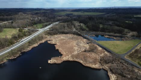 An-aerial-shot-captures-the-tranquil-lakescape-surrounding-a-sparsely-used-two-lane-road