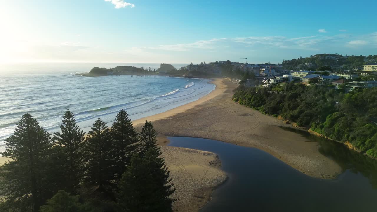 Drone luftfoto av Terrigal strand, buktende lagune, forstrand, havbølger, furutrær, kanalinntak, landlig forstadsby, morgensoloppgang, Central Coast Australia