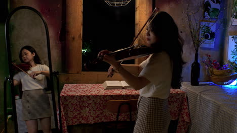 Mirror-captures-reflection-of-cute-female-wearing-short-skirt-playing-violin-at-home