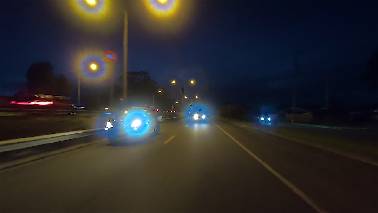 punto de vista de conducción nocturna mirando hacia atrás para el reemplazo de la pantalla verde de la escena interior del automóvil - autopista suburbana moderadamente transitada