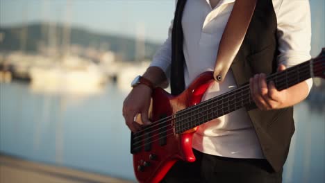 man playing bass guitar outdoors